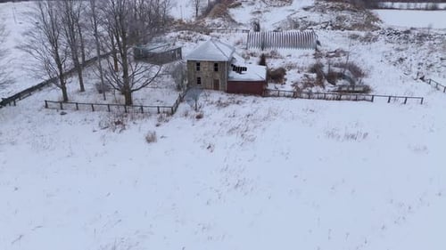 Aerial Drone Shot of Abandoned House in Snow Covered Winter Landscape