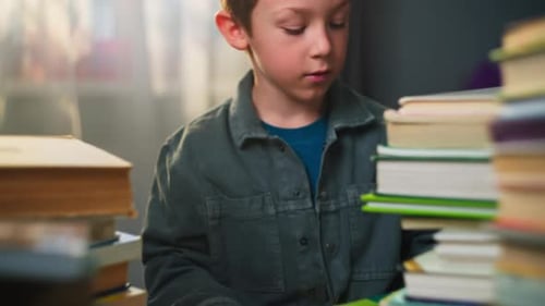 School Age Boy Sitting at a Desk at Home Reading a Book