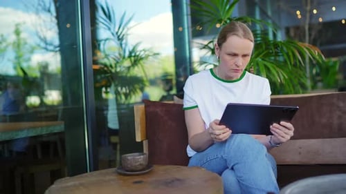 Focused Woman Using Tablet in Modern Cafe