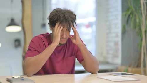 Young Adult Massaging Temples at Desk