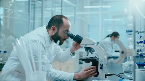 Scientist Using Microscope in Modern Laboratory Setting