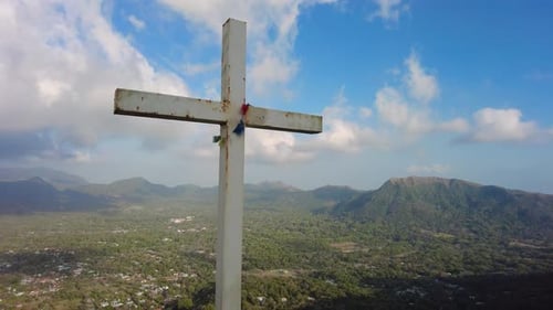 A towering crucifix perched atop a majestic mountain, surrounded by pristine natural beauty.