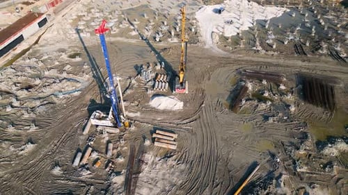 Eine Baustelle mit schweren Maschinen zum Bohren und Vorbereiten von Fundamenten, Pfählen, Bewehrung und Schlamm