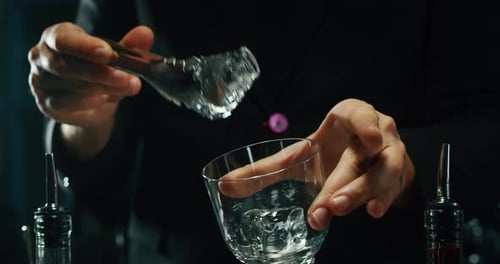 Close up of a professional bartender is preparing an alcoholic cocktail with professional crystal