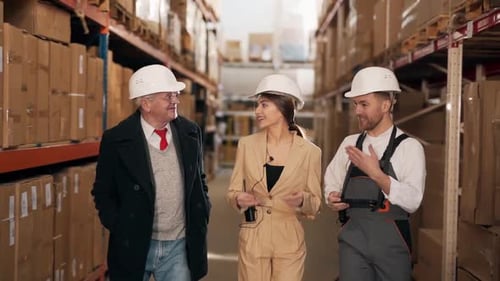 Warehouse Workers Walking Down Aisle Talking