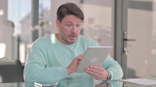 Man Works at Home and Celebrates Success With Tablet