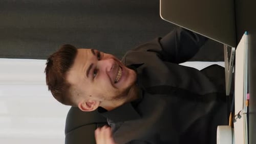 Enthusiastic Man Celebrates Success at Office Desk