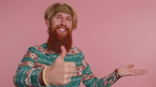 Hippie Man Showing Thumbs Up and Pointing Empty Place Advertising Area for Commercial Text Promotion