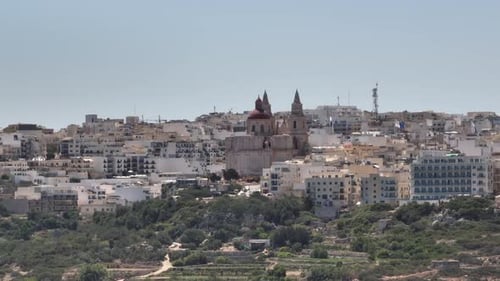 Parish Church of Mellieha On Coast Of Mellieha Bay In Mellieha, Malta. drone sideways shot