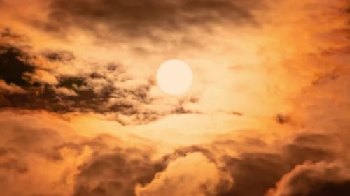 Timelapse of dramatic sunset with orange sky in a cloudy day.