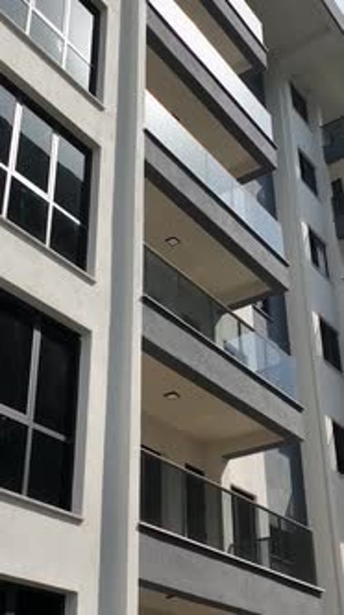Vertical Video Aerial Unveiling of New Residential Complex Windows and Balcony Glass Elegance