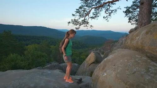 Hiker Woman Clambering on Rocky Mountain Footpath in Evening Nature