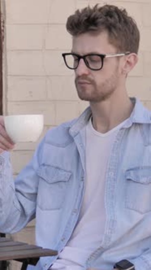 Relaxing Man Drinking Coffee while Sitting Outdoor in Cafe, Vertical Video