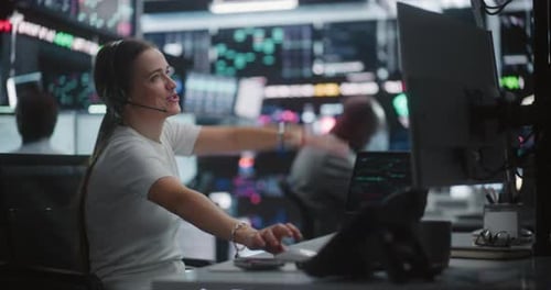 Relieved Female Trader Celebrating Profit Growth at Multi Monitor Workstation