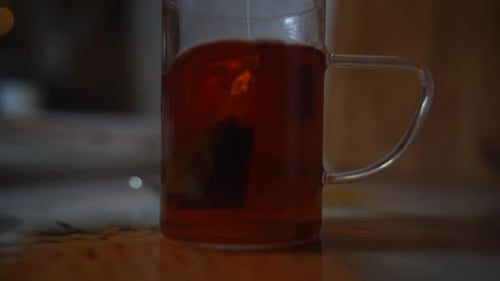 Teebeutel in einem Glas Tee. Morgentee zubereiten. Schwarzteebeutel in einem Glasglas aufbrühen.