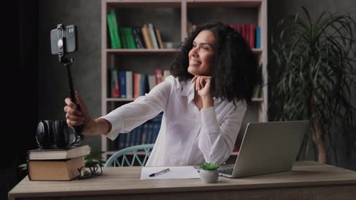 Smiling Woman Records Video at Home Office