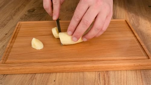 Slicing a Banana on a Wooden Cutting Board
