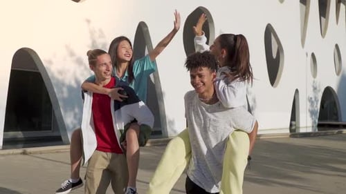 Multiethnic Group of Young Happy Friends Walking Down the Street Hitting High Five