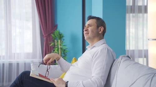Man Reading Book and Relaxing at Home