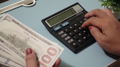 Mujer presionando con las manos los botones de la calculadora analizando los ingresos del negocio