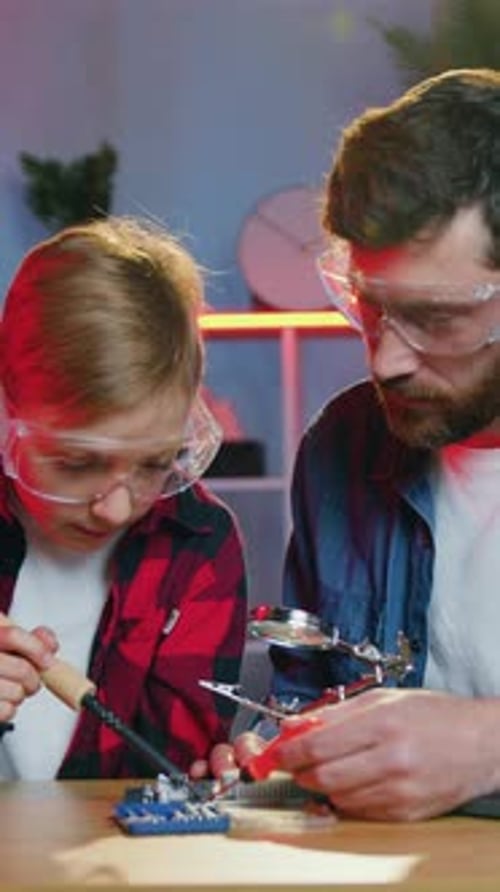Father and Son Soldering Electronic Components at Home