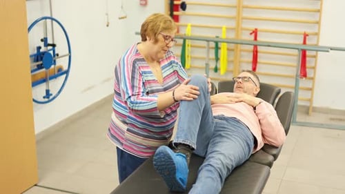 Physical Therapist Working With Man on Leg Extension