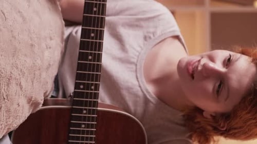 Woman Playing Acoustic Guitar at Home
