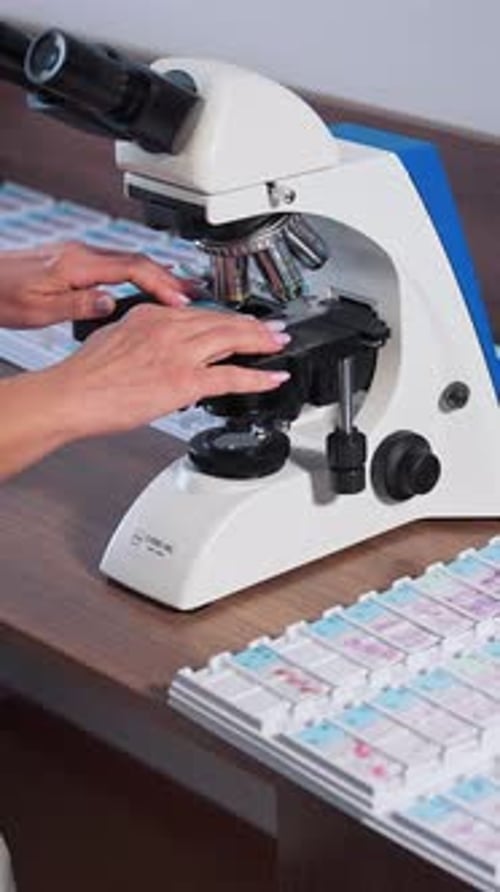 Doctor during biochemical analysis. Drop of samples between two microscope slides. Vertical video