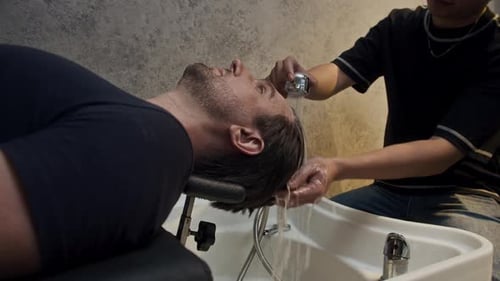 Man Gets Hair Washed at Barber Shop