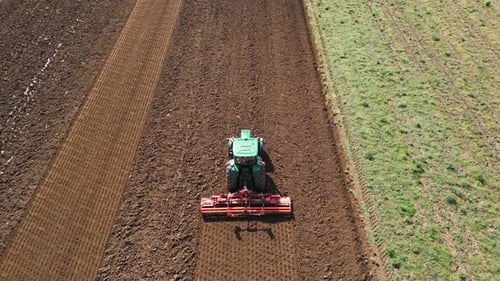 Ein Landwirt, der einen Traktor benutzt, um die Felder für die Bepflanzung vorzubereiten Das Bild unterstreicht die Bedeutung von