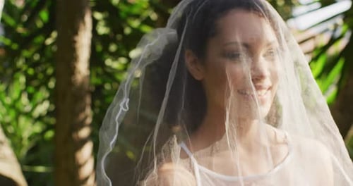 Smiling Bride in Veil With Green Foliage