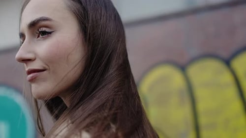 Beautiful Young Woman Posing Outdoors by Graffiti Wall