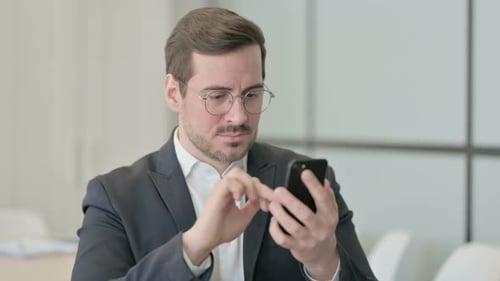 Portrait of Businessman Reacting to Loss on Smartphone