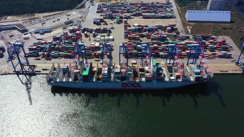 Container ship in export and import business and logistics. Shipping cargo to harbor by crane. Water