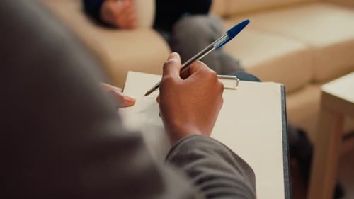 Thérapeute masculin prenant des notes sur des articles lors d'une