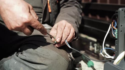 Man Wiring Electronic Components with Screwdriver