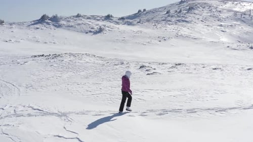 Walking up in mountains alone expedition - Young woman confident hiking on mountains covered with sn