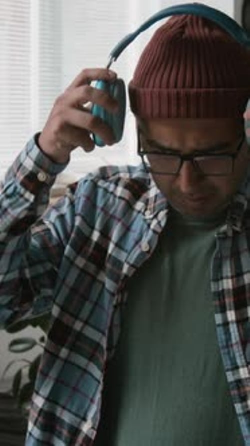 Happy Indian Male Developer Coding and Enjoying Music at Work