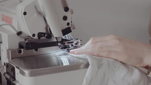 Craftswoman Concentrating on Sewing Fabric in Workshop