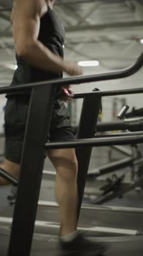 Young Man Running on Treadmill during Cardio Workout in Gym