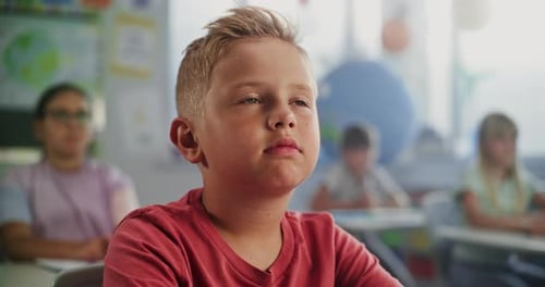 Close Up of Elementary School Boy Sitting at the Desk Listening to Lecture From Teacher