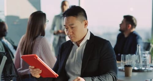 Professional man uses tablet at bright office meeting