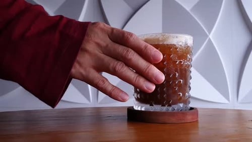 Cold Brewed Americano Coffee over Ice with hand holding the glass