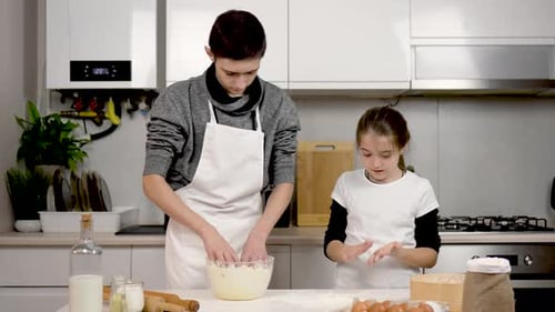 Teenage Children Making Dough for Holiday Cookies Boy Young Chef Testing Cooking Skills at Home Girl