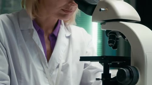 Scientist Woman Using Microscope in Laboratory Setting