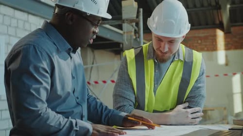 Architect Explaining Floor Plan and Giving Handshake to Building Contractor