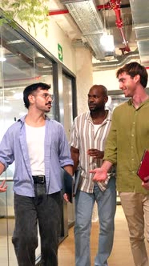 Three Diverse Male Colleagues Walking and Talking in Modern Office Hallway