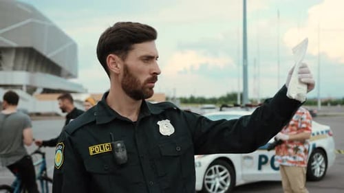 Police Officer Holding Evidence Bag at Crime Scene