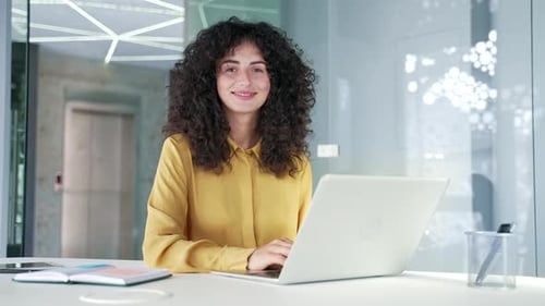 Woman Typing on Laptop in Office Setting