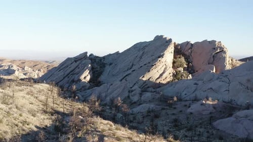 A wide shot of the Devil's Punchbowl rock formation in California, showing the rugged terrain and un